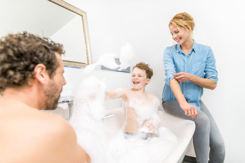 Papa und Sohn baden zusammen und Mama schaut zu