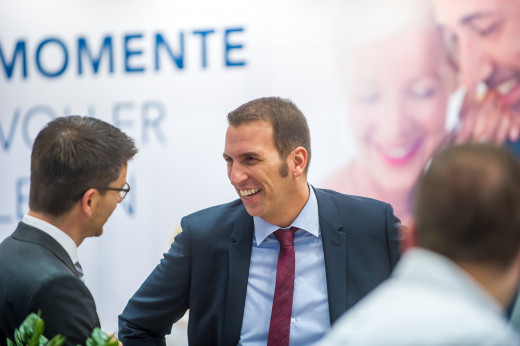 Zwei Männer lachen bei einem auf einer Messe