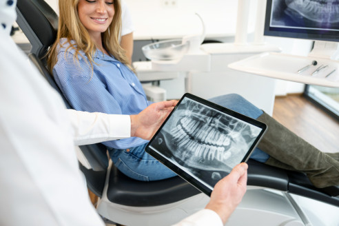 Zahnarzt spricht mit Patientin