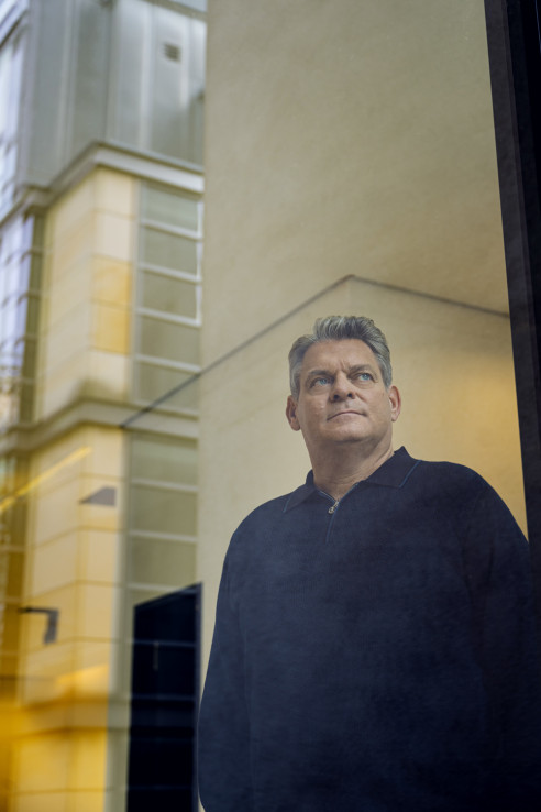 Geschäftsführer Portrait im Büro vor einer Glasscheibe