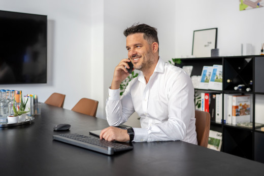 Businessportrait eines Geschäftsführers beim Telefonieren am Schreibtisch