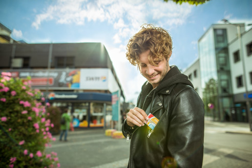 Junger Mann holt gerade eine Vorteilskarte raus