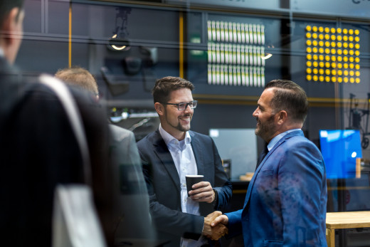 Zwei Männer begrüßen sich auf einer Messe