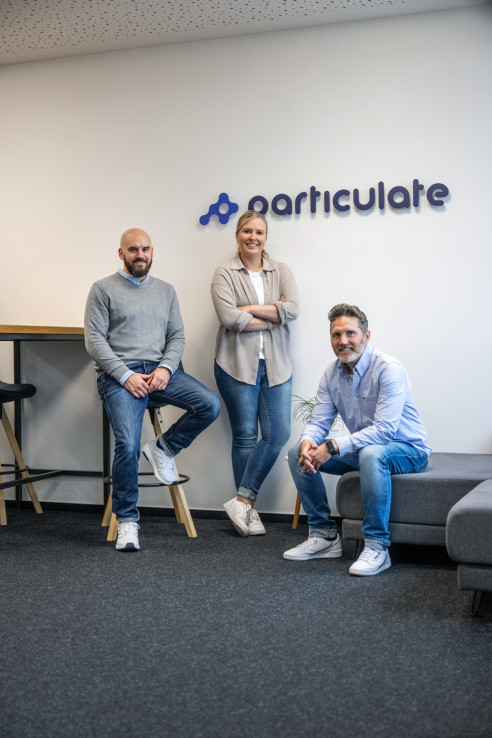 Geschäftsführer Portraits im Büro vor dem Firmenlogo