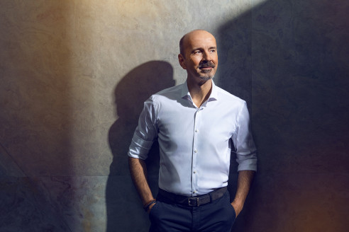 Businessportrait eines Geschäftsführers vor einer grauen Wand