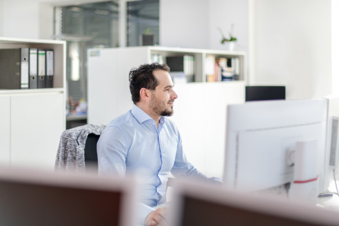 Mitarbeiter bei der Arbeit am Schreibtisch.