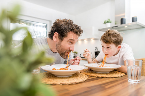 Papa und Sohn essen nudeln